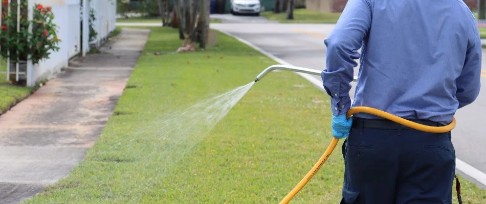 Crew applying chinch bug control treatment on grass in Miramar, FL.