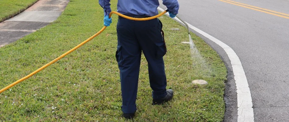 Crew spraying a lawn in Miami Beach, FL, with fertilizer treatment.
