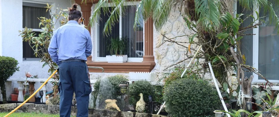 Crew spraying a weed control treatment on a landscape bed in Miramar, FL.