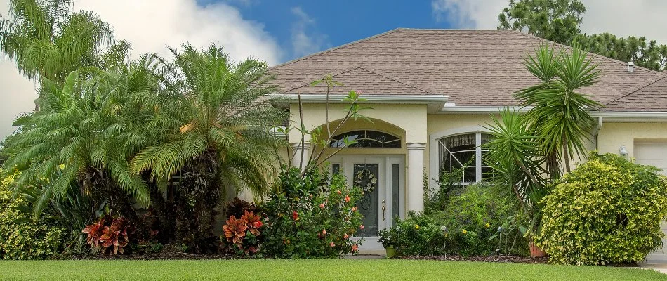 A home in Coral Springs, FL with trees and shrubs in the entryway.