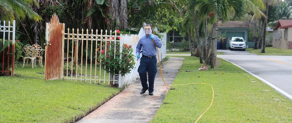 Professional treating a lawn in Miramar, FL, with fertilizer treatment.