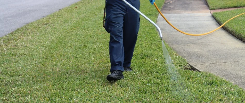 Lawn care employee spraying lawn at a residence in Southwest Ranches, FL.