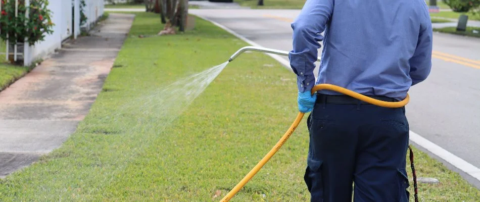 Tech spraying fertilizer on grass in Sunrise, FL.