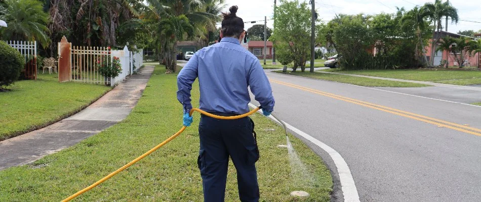 Technician spraying a liquid fertilizer treatment on a lawn in Key Biscayne, FL.